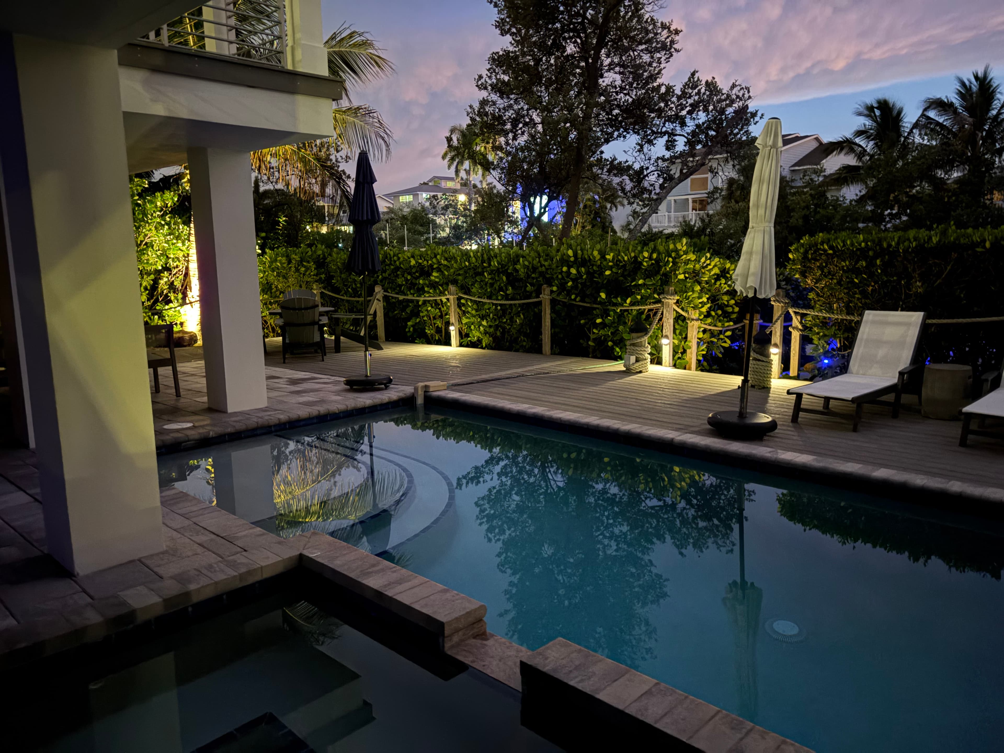 Solid brass pool deck and accent lighting at dusk on a Sarasota waterfront property